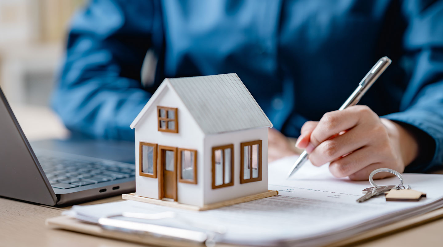 Mains signant un document contractuel dans un bureau américain, représentant la finalisation d'un achat immobilier par un non-résident